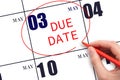 Hand writing text DUE DATE on calendar date May 3 and circling it. Payment due date Royalty Free Stock Photo