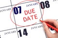 Hand writing text DUE DATE on calendar date January 7 and circling it. Payment due date Royalty Free Stock Photo