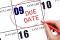 Hand writing text DUE DATE on calendar date January 9 and circling it. Payment due date Royalty Free Stock Photo