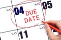 Hand writing text DUE DATE on calendar date May 4 and circling it. Payment due date Royalty Free Stock Photo