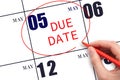 Hand writing text DUE DATE on calendar date May 5 and circling it. Payment due date Royalty Free Stock Photo