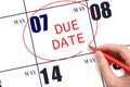 Hand writing text DUE DATE on calendar date May 7 and circling it. Payment due date Royalty Free Stock Photo