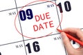 Hand writing text DUE DATE on calendar date May 9 and circling it. Payment due date Royalty Free Stock Photo