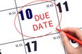 Hand writing text DUE DATE on calendar date May 10 and circling it. Payment due date Royalty Free Stock Photo