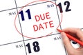 Hand writing text DUE DATE on calendar date May 11 and circling it. Payment due date Royalty Free Stock Photo