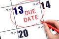 Hand writing text DUE DATE on calendar date May 13 and circling it. Payment due date Royalty Free Stock Photo