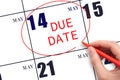 Hand writing text DUE DATE on calendar date May 14 and circling it. Payment due date Royalty Free Stock Photo