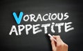 Hand writing Voracious appetite on blackboard, concept background