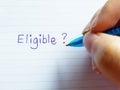 Equality and Diversity concept A hand writing the word Eligible on a piece of paper Royalty Free Stock Photo