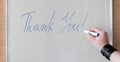 Hand writing the words THANK YOU on white blackboard Royalty Free Stock Photo