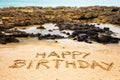 Rocks, water, sand and happy birthday Royalty Free Stock Photo