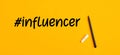 Hand written influencer word with hashtag symbol and a pen marker on yellow background. Social media influencer Royalty Free Stock Photo