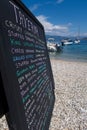 Hand Written Menu On Beach Outside Greek Taverna