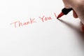 Hand written thank you message with a red pen on white background, gratitude concept. Royalty Free Stock Photo