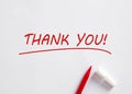 Hand written Thank You message with a red pen on white background. Gratitude concept