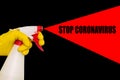 Hand in a yellow glove with a disinfectant on a black background. Poster with text stop coronavirus Royalty Free Stock Photo