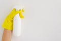 Hand with yellow glove holding a blank white spay bottle closeup on clean background. Mock up bottle clean. Copy space Royalty Free Stock Photo