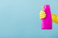 Hand in yellow glove holds a bottle of bleach on white background. cleaning Royalty Free Stock Photo