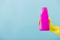 Hand in yellow glove holds a bottle of bleach on white background. cleaning Royalty Free Stock Photo