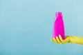 Hand in yellow glove holds a bottle of bleach on white background. cleaning Royalty Free Stock Photo