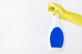 Hand in yellow glove holds spray bottle of liquid detergent on white background. cleaning Royalty Free Stock Photo