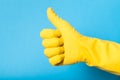 Hand in yellow glove, plastic latex. Thumbs up