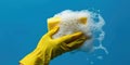 Hand in yellow glove pressing soapy sponge against blue background, cleaning service banner Royalty Free Stock Photo