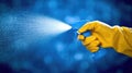 A hand in a yellow glove sprays a cleaning solution against a blue background Royalty Free Stock Photo