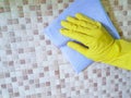 Hand yellow gloves domestic household indoor washer house window with a blue rag glass