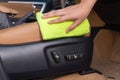 Hand with yellow microfiber cloth cleaning in car sittings elect