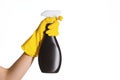 A hand in a yellow protective rubber glove holds a black bottle of detergent on a white background isolate. Cleaner for various ki Royalty Free Stock Photo