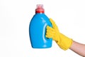 A hand in a yellow protective rubber glove holds a blue bottle of detergent or laundry detergent on a white background, isolate Royalty Free Stock Photo
