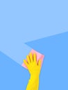 Hand in yellow rubber glove with pink cleaning sponge leaves clean stripe on top on blue background with copy space Royalty Free Stock Photo