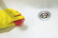 Hand in yellow rubber glove with sponge wash sink Royalty Free Stock Photo