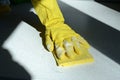 Hand in yellow rubber glove washing kitchen surface lit by the sun Royalty Free Stock Photo