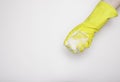 Hand in an yellow rubber glove with an yellow sponge and foam on a white background. Washing dishes, cleaning, home cleaning. Royalty Free Stock Photo