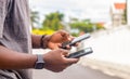 Hand of a young black african man seen from the side holding a smartphone at a construction site in the city Royalty Free Stock Photo