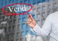 Hand of young businessman write the word Vend on skyscrapers background.