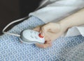 The hand of a young caucasian male patient lying in bed and holding a remote control in his hands Royalty Free Stock Photo