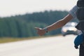 Hand of a young guy who honks on the road, hitchhiking Royalty Free Stock Photo