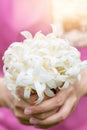 Hand of young holding a bouquet of jasmine with sun light.