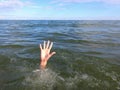 hand of the young man in distress who drowns in the ocean