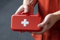 Hand of a young man firmly holding a first aid kit