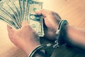 Hand young man in handcuffed hold money