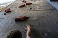 Hand of the young man on a hook of the artificial climbing wall