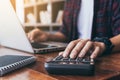 Hand of young man using calculator and notebook in library room Royalty Free Stock Photo