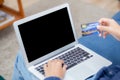 Hand of young man using laptop computer display blank screen shopping online with credit card on sofa at home. Royalty Free Stock Photo