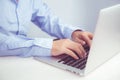 Hand of young man working on laptop computer on table at home office, male typing keyboard notebook on desk. Royalty Free Stock Photo