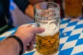 Hand of young people lifting glasses of beer at the Oktoberfest germany Soft focus. Shallow DOF
