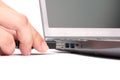 The hand of a young woman connects a USB flash drive to a port in a laptop with a black keyboard. Isolated on white background Royalty Free Stock Photo